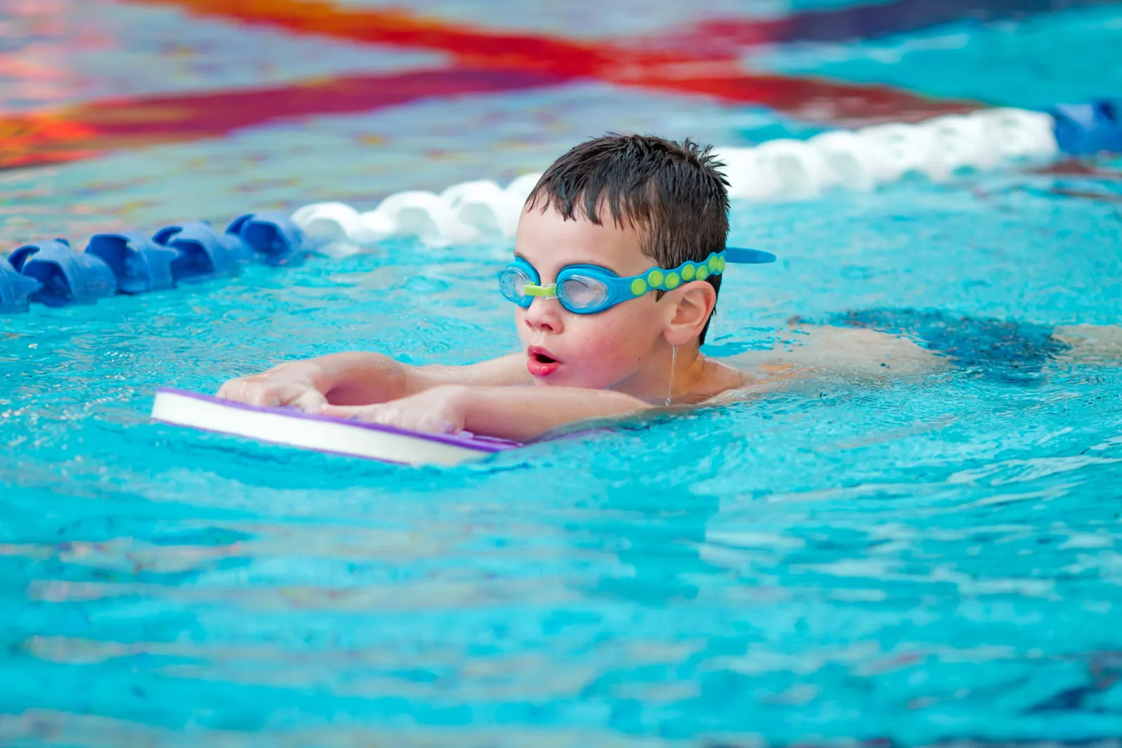 Child practising swimming skills with an instructor